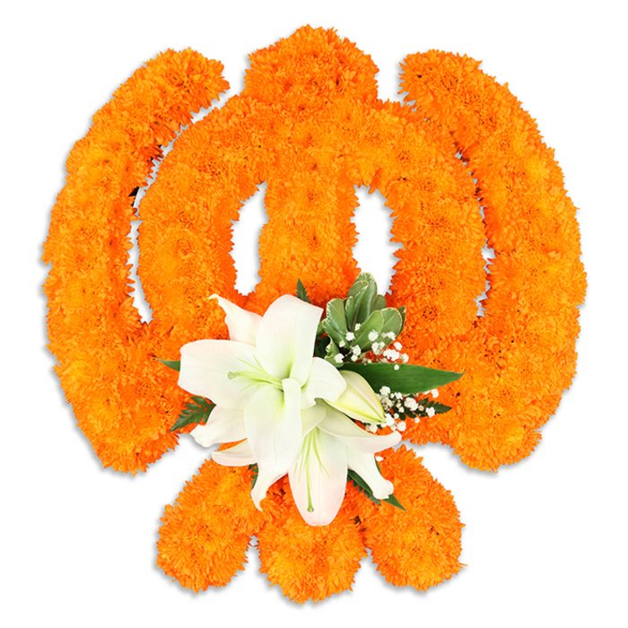 Bright orange marigolds have been clustered with exacting care to form the celebrated Sikh Khanda, their dense, rounded heads creating a sculptural surface that reads like woven fabric against a stark white background. The emblem's defining elements-the circular chakkar, the two crossed kirpans and the central khanda blade-are each modelled from these compact marigold tufts so that their edges hold clear, luminous contours under soft lighting. At the emblem's centre, a bouquet of pristine white lilies provides a striking focal point: two or more fully open lilies show smooth, luminous petals and pale green-yellow stamens, joined by tighter buds and slender stems. Fine sprigs of white filler blooms, possibly gypsophila, and deep green foliage tuck in around the lilies, their textures and colours gently modulating the bold orange field and adding dimensionality. The arrangement casts a subtle shadow, implying a freestanding ceremonial board or tribute display commonly seen during festival decorations or memorial services within local Gurdwaras and community halls near Golders Hill Park and Finchley Road. Visually and emotionally, the combination reads as a conversation between exuberance and serenity-the marigolds' warmth celebrating communal joy and the lilies' cool purity invoking contemplation and respect. A florist would notice too the implied scents: the faint, earthy sweetness of marigold softened by the lilies' clean, almost powdery perfume-an effect designed to comfort and uplift during Vaisakhi, Gurpurab or special commemorations throughout Golders Green.