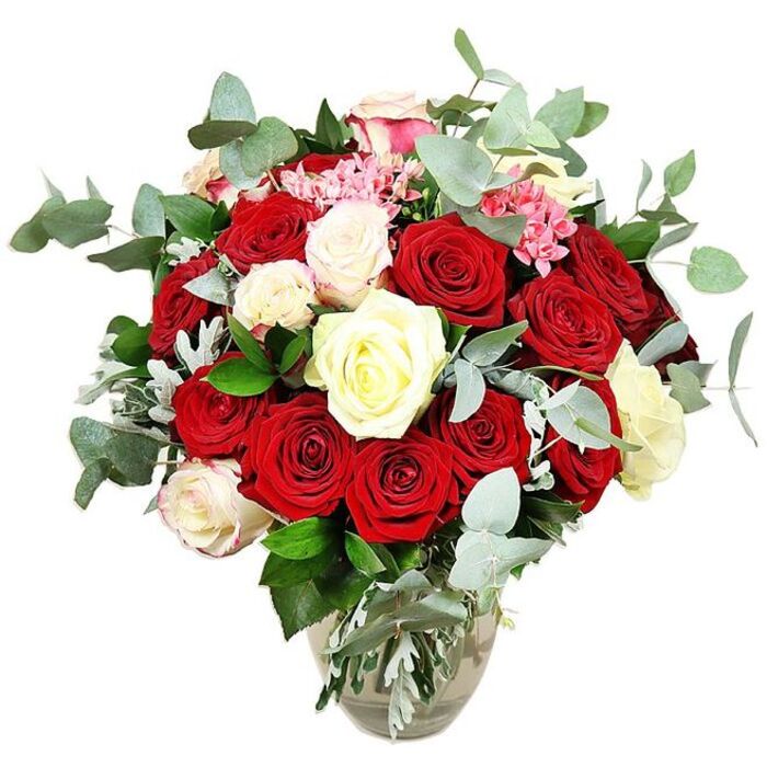 A sumptuous rose arrangement sits confidently in a clear glass vase against a seamless white background, the composition designed to showcase every curve of petal and leaf. The bouquet is dominated by an opulent gathering of red roses in shades of deep crimson and bright scarlet, some tightly furled with a sense of anticipation, others stretched wide open, revealing velvety, layered centres that evoke passion, devotion, and the comfort of familiar romance. Interspersed among these bold tones are elegant white and creamy ivory roses, their smooth petals reflecting the light and adding a calm, refined contrast. Here and there, a few of the paler blooms show the faintest blush of pink along their edges, lending a hint of tenderness and softness. Nestled between the larger roses are petite clusters of vivid pink filler flowers, which may be mini carnations or another small, clustered variety, providing subtle texture and a cheerful accent that breaks up the solid blocks of colour. Flowing around the blooms, plentiful stems of eucalyptus with rounded, blue-green leaves create a modern halo and hint at a cool, aromatic freshness. Deeper green foliage and a whisper of silvery leaves tuck into the base, filling out the arrangement and enhancing its rounded, generous silhouette. The glass vase, with its gently bulbous base and narrowing neck, reveals the neatly gathered green stems and clear water inside, adding a simple, natural counterpoint to the luxurious blossoms above. With its clean, white setting and carefully balanced palette, the bouquet feels like an ideal centrepiece for an intimate celebration dinner in Golders Green, perhaps after a stroll through nearby Golders Hill Park, or as an expressive anniversary gift delivered to family living along Finchley Road.