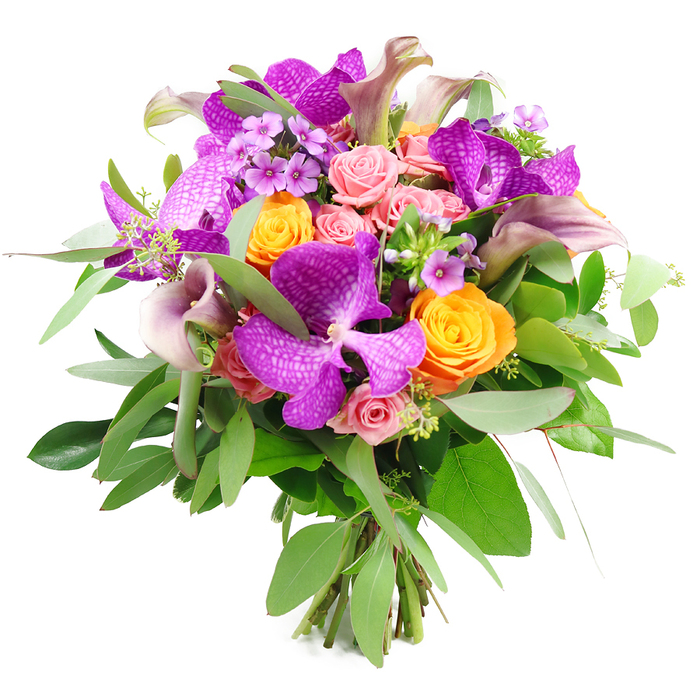A vibrant, meticulously composed bouquet bursts with colour against a pure white studio background, highlighting the interplay of purples, oranges, and soft pinks. Dominating the eye are several large Vanda orchids in saturated fuchsia-purple tones, each flower unfurling broad, slightly ruffled petals veined and speckled with a delicate, netted pattern that instantly gives the design an exotic, high-end character. Between these striking orchids sit clusters of bright orange roses, their blossoms dense and spiralled, catching the light on their softly satiny petals. Intermixed are blush and pastel pink roses in various stages of opening, from tight, promising buds to partially unfurled blooms with layered, romantic hearts, lending the arrangement a tender, almost nostalgic charm. Rising from within the main body of flowers, slender calla lilies in shades of mauve, dusky plum, and muted lavender reach upward, their smooth, trumpet-like forms adding graceful lines and a hint of drama. Encircling the flowers is a generous collar of foliage: silvery-green eucalyptus leaves provide a misty softness, while darker, glossier green leaves deepen the contrast and frame the bouquet like a carefully painted backdrop. Tiny accents of lavender-hued filler flowers and light green sprigs are threaded throughout, creating fine, almost lace-like detail when viewed closely. The stems are neatly gathered and exposed at the bottom, clearly indicating a hand-tied, professional design crafted with care. This opulent bouquet feels perfect for a special celebration in Golders Green-perhaps set on a Shabbat table near Temple Fortune or delivered as a meaningful anniversary gift-radiating luxury, artistry, and heartfelt sentiment.