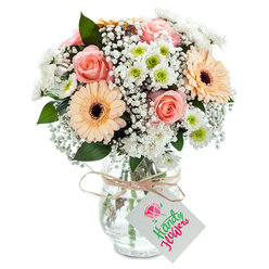 Reminiscent of a gentle morning in Golders Green as sunlight filters through garden leaves, this bouquet surrounds you with a soothing blend of colour and calm. Plush, peach-kissed roses unfurl at the heart, their silky petals and romantic spirals conjuring tender shared moments in Golders Hill Park. Side by side, two peach-orange gerbera daisies present with broad, spirited petals and dusky centers, their presence as cheerful as the village atmosphere along Finchley Road. Sprigs of baby's breath meander throughout, airy as a soft breeze, tempering the composition with lightness and serenity. Small, white chrysanthemums add a refreshing touch of brightness, their lime-green centers reminiscent of the first flush of spring around Hampstead Heath Extension. Subtle eucalyptus leaves appear here and there, adding a fragrant, green accent and tying the bouquet's scents to the area's tree-lined streets. Gathered in a classic clear glass vase, the flowers' stems are arranged in crisp water, a visible testament to freshness and care. A length of rustic twine neatly encircles the neck, holding a clean, unmarked white tag-inviting a personal dedication for any meaningful occasion. Whether gracing a family table or expressed as a loving gesture, this bouquet perfectly embodies the grace and artistry of Golders Green's trusted local florists.