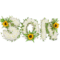 Photographed on a stark white background, this bespoke sympathy piece spells SON in solid capital letters formed from hundreds of pristine white chrysanthemums, each blossom layered to create a plush, tactile surface that appears almost cloudlike beneath soft, directional lighting. Dark green ivy vines are artfully threaded through every letter, their glossy leaves providing graceful lines that frame the chrysanthemums and introduce an evergreen symbolism of lasting remembrance. Sprays of lighter green fern fronds and slender foliage lift the composition with airy texture, while three cheerful sunflowers punctuate the design-one tucked into the upper-left curve of the S, one seated low in the O among the ferns, and one perched at the upper-right of the N. The sunflowers' vivid yellow petals and deep brown centres lend warmth and an optimistic note, suggesting the small brights of memory even amid mourning. As a florist serving Golders Green and the surrounding NW11 community, Flowers Golders Green often creates memorial letters like this for funerals, cemetery placements, and family tributes, carefully balancing proportion, scent, and structure so the arrangement reads clearly from a distance yet invites close, personal regard. The overall impression is one of respectful craftsmanship-the soft white chrysanthemums symbolising peace, the rich greenery signalling life's continuity, and the sunflowers offering tender affection-captured in a photograph that preserves the texture, colour, and quiet emotion of the tribute.