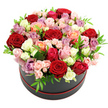 A lavish collection of roses overflows from a round black hat box, forming a perfectly rounded, dome-like silhouette that feels both polished and indulgent. The design is built from countless rose heads pressed closely together so there are no gaps, just a continuous sea of petals. Deep, romantic reds anchor the arrangement, gradually melting into blush pinks, pastel creams, vivid fuchsias, warm peach and coral, and delicate lavender and mauve at the edges. The transition of colours is smooth and intentional, like a gradient painting, giving the eye a gentle path to follow across the bouquet. The roses themselves show different stages of openness: some are fully bloomed with wide, spiralling centres, others are just beginning to open, and groups of tiny spray roses dot the spaces between, adding intricacy and charm. Slender, bright green leaves appear at intervals, offering a crisp counterpoint to the richness of the petals and ensuring the composition never feels heavy. The hat box is a sophisticated matte black accented with a narrow red trim at the base, which quietly echoes the central red blooms without competing for attention. Photographed against a stark white background, the colours have maximum impact, every soft petal edge and shadow visible as though you were leaning in close. The mood is unmistakably romantic and celebratory, ideal for anniversary dinners, milestone birthdays, or a heartfelt thank-you gesture across Golders Green. Imagining this piece delivered to a townhouse near Childs Hill or a flat close to the station, it becomes more than a bouquet; it feels like a thoughtfully crafted centrepiece that transforms an everyday space into somewhere special.