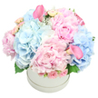 This bouquet is pure poetry in pastels, a harmonious symphony of delicate and lush textures that glows softly under gentle morning light. Pale hydrangea clusters form cushions of cloudlike blue beside the frilled pink peonies, whose petals catch and hold the light as if each layer breathes. Sprigs of cream and blush spray roses slip between the blooms, their fragrance faint but very present, lending an air of quiet romance and reassurance. The arrangement rests in a round white hat box, its clean lines allowing the flowers to sing with a contemporary, gallery-fresh clarity. If you could lean in, you'd feel the velvet softness of the peonies against the satin gloss of the calla lilies, a tactile contrast that delights the fingertips as well as the eyes. A hint of silvery greenery-dusty miller and slender green leaves-traces the rim, framing the pastel blossoms with gentle depth. The overall effect is calm, hopeful, and beautifully balanced, a bouquet that would suit a heartfelt congratulations, a birthday, or a thoughtful gesture to welcome a new baby here in Golders Green. In our local studio on The Broadway, we imagine this piece brightening a mantel or a windowsill in a family home, catching soft daylight from morning until early evening. It speaks of refined celebration rather than fanfare, a quiet gift that says you care without shouting. Available for same-day delivery across Golders Green and nearby suburbs, this arrangement is both timeless and contemporary, a delicate expression of kindness crafted by a skilled local florist.
