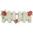 A dignified, three-dimensional tribute that reads 'MOM', composed entirely of tiny, pristine white spray chrysanthemums packed to a soft, cushion-like depth and set against a clean white backdrop. The surface of each letter feels almost cloud-soft to the eye: hundreds of small florets pressed closely together to create a calm, uniform plane that absorbs daylight and lends the piece a quiet poise. To give the arrangement warmth and focused emotion, three glossy red anthuriums punctuate the white-one placed on the top left curve of the first 'M', a second nestling at the base of the central 'O', and a third crowning the top right of the final 'M'-each showing its pale yellow spadix and surrounded by feathery fern sprays and broader dark green leaves. Narrow, arching blades of grass or stem-like foliage link the red blooms across the white letters, their graceful lines unifying the composition while the subtle dark green structural frame peeks out along edges to hold the shapes firm.
The lighting is soft and natural, as if arranged in gentle morning light found near Golders Green's quieter streets, imparting a sense of peaceful reflection. Texturally and emotionally this is a classic funeral tribute-pure whites for peace, red for enduring love-offered with the restraint and respect appropriate for a memorial service, wake, or graveside gathering at nearby chapels and the Golders Green Crematorium. The overall feeling is one of careful craftsmanship and tender remembrance, a comforting, personal way to honour a mother's life.